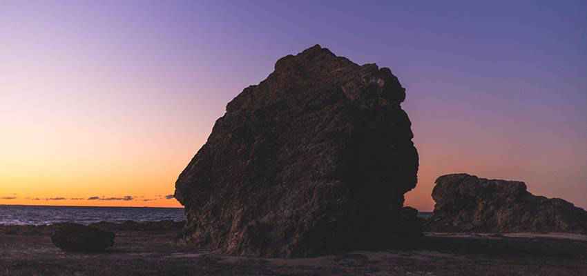 A large rock on a beach.