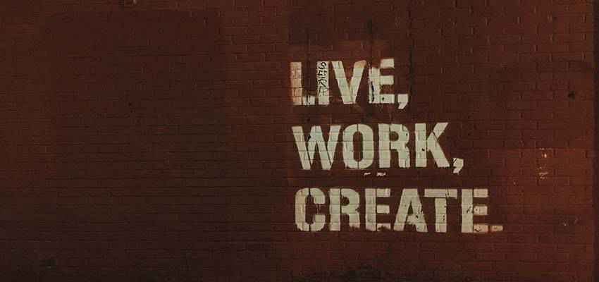 A wall with the words "Live, Work, Create" painted on it.