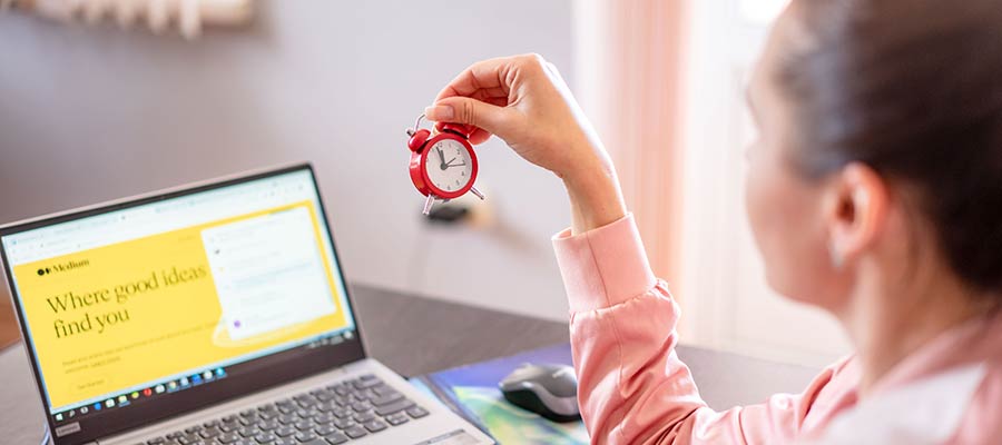 A woman holds an alarm clock.