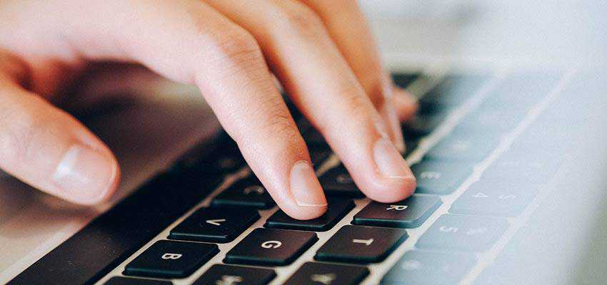 A hand typing on a keyboard.