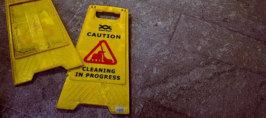 Cleaning signs lay on a floor.